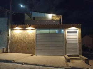a garage door with lights on the side of a building at Hospedagem ensolarada in Japaratinga