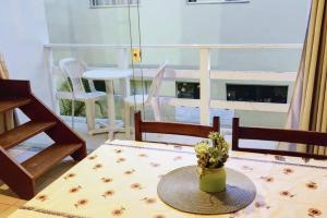 uma mesa com um vaso de flores sobre uma mesa em Espaçoso apartamento a 50mt do mar em Morro de São Paulo