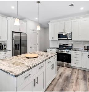 cocina con armarios blancos y encimera de mármol en Stunning vacation rental one block from the beach., en Seaside Heights