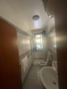 a bathroom with a sink and a toilet and a window at Villa Hidra near Cefalù in Buonfornello