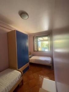 a small bedroom with two beds and a window at Villa Hidra near Cefalù in Buonfornello
