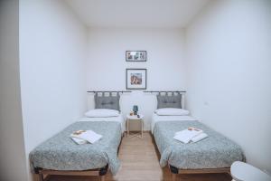 two twin beds in a room with a table at Dimora Pardo in Larino