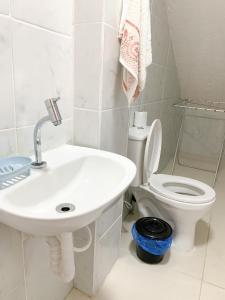 a white bathroom with a sink and a toilet at Studio Tranquilo in Florianópolis