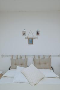 LarinoにあるDimora Pardoの白いベッドルーム(ベッド2台、壁掛け時計付)