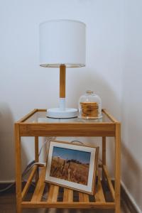 Dimora Pardo في Larino: طاولة صغيرة عليها مصباح وصورة
