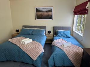 a bedroom with two beds with towels on them at New Lynn Self- Contained Unit near Golf Course in Auckland