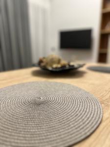 a round mat on a wooden table with a plate at Olive-Luxury apartment in agrinio in Agrinion