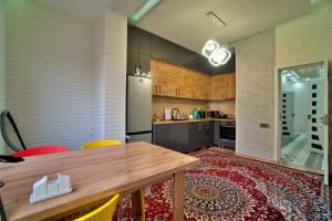 a kitchen with a wooden table and a refrigerator at Family 3-room apartment in Dushanbe