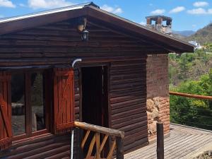 a log cabin with a porch and a door at Balcón de Los Aromos in La Bolsa