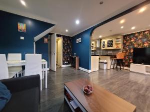 a living room with blue walls and a dining room at Cozy room London in Enfield