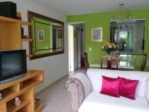 un soggiorno con un divano bianco e una TV di Suíte confortável para casal ou 2 mulheres a Balneário Camboriú