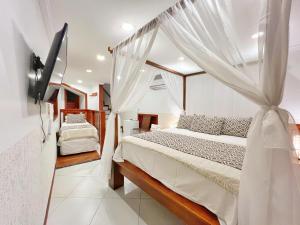 a bedroom with a bed with a canopy at Mini Hotel Dunas in Jericoacoara