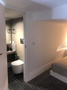 a bathroom with a toilet and a bed and a lamp at Salottino Carafa by Salotto Borbonico in Naples