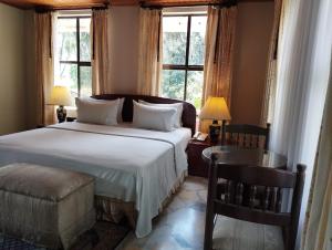 Sunsetfarmhotel في زيباكويرا: غرفة نوم بسرير كبير ونوافذ
