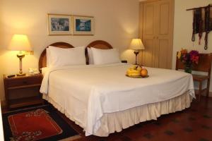 a bedroom with a bed with a bowl of fruit on it at Sunsetfarmhotel in Zipaquirá