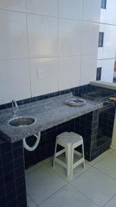 um balcão de casa de banho com um lavatório e um banco em Icaraí Budget em Caucaia