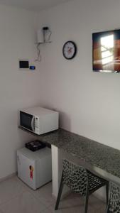uma cozinha com um balcão e um micro-ondas na parede em Icaraí Budget em Caucaia