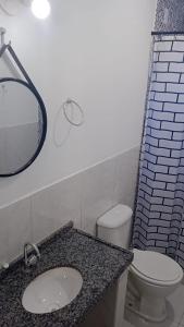 uma casa de banho com um lavatório, um WC e um espelho. em Icaraí Budget em Caucaia
