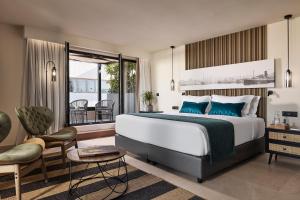 a bedroom with a large bed and a balcony at Athenarum Portus Life & Style Hotel in Piraeus