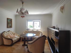 a living room with a table and chairs and a chandelier at Vila Šeki in Bar