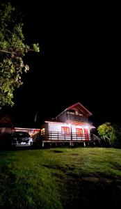 a house is lit up at night in a field at Tu Parcela en Carretera Austral in Hualaihué