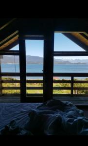 a bedroom with a bed and a view of the ocean at Tu Parcela en Carretera Austral in Hualaihué