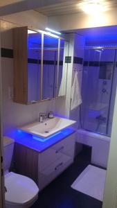 a bathroom with a sink and a toilet with blue lights at Semmering Studio-Apartment in Semmering