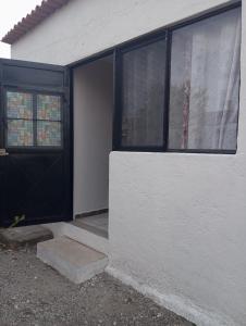 une maison blanche avec une porte et des fenêtres noires dans l'établissement Sweet Room, à Tequisquiapan