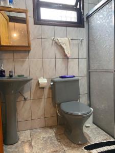 a bathroom with a toilet and a sink at LARA'S HOUSE in São Sebastião