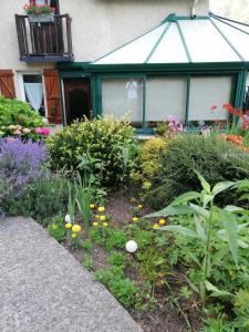 einen Garten mit Blumen und Pflanzen vor einem Haus in der Unterkunft MENFOUTI in Saint-Béat