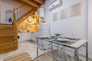 une cuisine avec une table, des chaises et une horloge murale dans l'établissement Casa entera con piscina privada, à Séville 7 autres photos