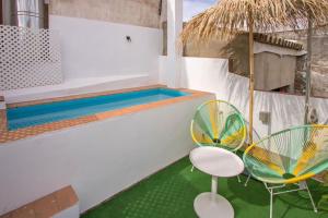 un patio avec deux chaises et une piscine dans l'établissement Casa entera con piscina privada, à Séville