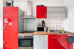 cocina con armarios rojos y nevera roja en 1Zimmer, Küche, Bad, EG Fewo Rupertsberg, en St. Georgen im Schwarzwald 8 fotos más