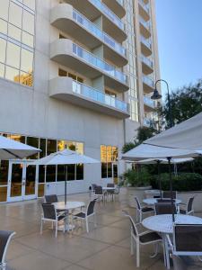 an outdoor patio with tables and chairs and umbrellas at MGM Signature Condo Hotel by Owner - No Resort Fee !! in Las Vegas