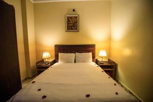 a bedroom with a large bed with two nightstands and two lamps at Bella Casa Pyramids Inn in Cairo