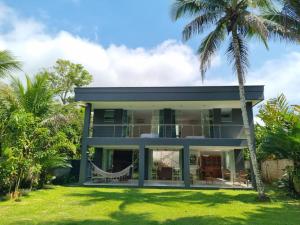 a house with palm trees in front of it at Paraiso em Angra dos Reis in Angra dos Reis