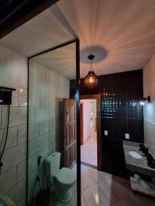 a bathroom with a toilet and a sink and a mirror at Casa Mar in Armacao dos Buzios