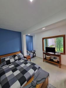a bedroom with a checkered bed and a television at Casa Mar in Armacao dos Buzios