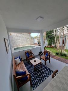 a porch with a bench and a swimming pool at Casa Mar in Armacao dos Buzios