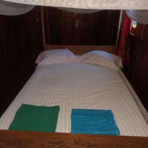 Blue Sea Guest House في بصير: سرير وفوط خضراء عليه