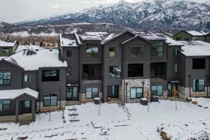 un immeuble dans la neige avec des montagnes en arrière-plan dans l'établissement Modern Mountain Escape, à Morgan