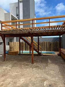 eine Holzbank mit einer Leiter neben einem Pool in der Unterkunft Casa de playa y sol in Monte Hermoso