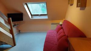 a living room with a pink couch in a room with a window at Appartement au pied de la Crémaillère Express in Luchon