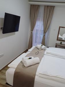 Habitación con 2 camas, toallas y TV de pantalla plana. en Villa Sweet Dreams en Novi Sad