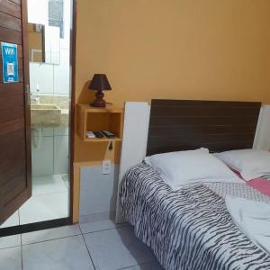 1 dormitorio con 1 cama, lavamanos y lámpara en pousada cangaço, en São Gonçalo do Amarante