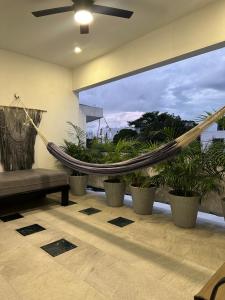 een hangmat in een kamer met potplanten bij Oasis Urban Retreat in Cancun