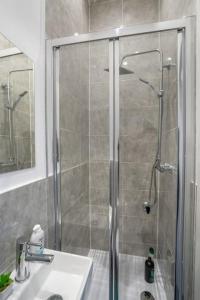 ducha con puerta de cristal junto a un lavabo y baño en `isimi Luxurious 4 bed 4 ensuite house en Barrow in Furness