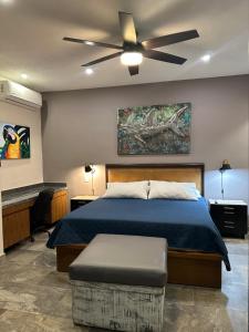 een slaapkamer met een bed en een plafondventilator bij Oasis Urban Retreat in Cancun