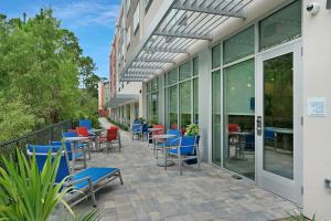a patio with chairs and tables outside of a building at Holiday Inn Express - Jacksonville South Bartram Prk, an IHG Hotel in Jacksonville
