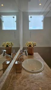 a bathroom with a sink with flowers on a counter at Estúdio Arruda in Itacaré